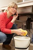 pic of leak  - Woman Mopping Up Leaking Sink On Phone To Plumber - JPG 