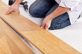stock photo of floors  - Installing laminate flooring fitting the next piece  - JPG 