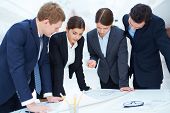 stock photo of meeting  - Team of engineers learning blueprint at meeting - JPG 