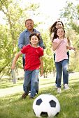 stock photo of family  - Family playing football in park - JPG 