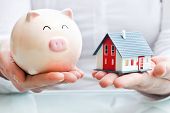 picture of industrial  - Hands holding a piggy bank and a house model - JPG 