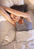 picture of wake  - Smiling woman lying on bed wakes up to a beautiful morning - JPG 