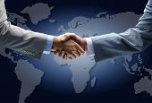 stock photo of handshake  - Handshake with map of the world in background - JPG 