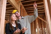 foto of construction worker  - A home construction worker pointing out something for the client - JPG 