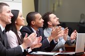 stock photo of meeting  - Multi ethnic business group greets somebody with clapping and smiling - JPG 