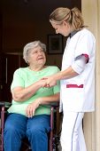 picture of handshake  - Nurse and senior patient in a wheelchair gives each other a handshake - JPG 