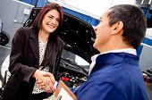 foto of handshake  - Happy woman handshaking with a mechanic after a good service - JPG 