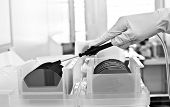 stock photo of silicon  - The hand of a researcher in a cleanroom picking up a silicon wafer commonly used in the semiconductor industry to make electronic devices
 - JPG 