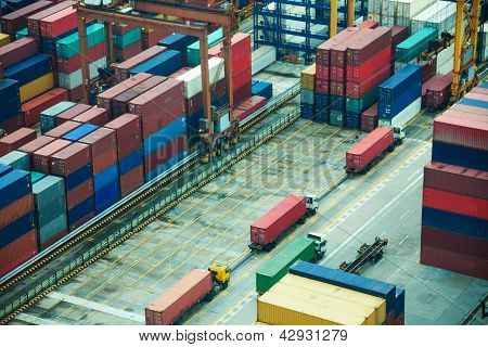 Picture or Photo of Line of trucks in sea port with many containers waiting to be shipped