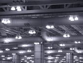 stock photo of discharge  - Overhead commercial lights fixtures with mercury vapor discharge lamps hanging from the ceiling of a large industrial building - JPG 