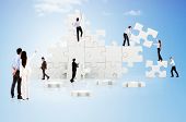 stock photo of puzzle  - Business teamwork in action creating a puzzle on the cloud - JPG 