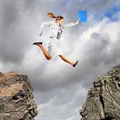 picture of gap  - Image of young businesswoman jumping over gap - JPG 