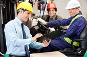 picture of industrial  - Happy male supervisor communicating with forklift driver and foreman at warehouse - JPG 